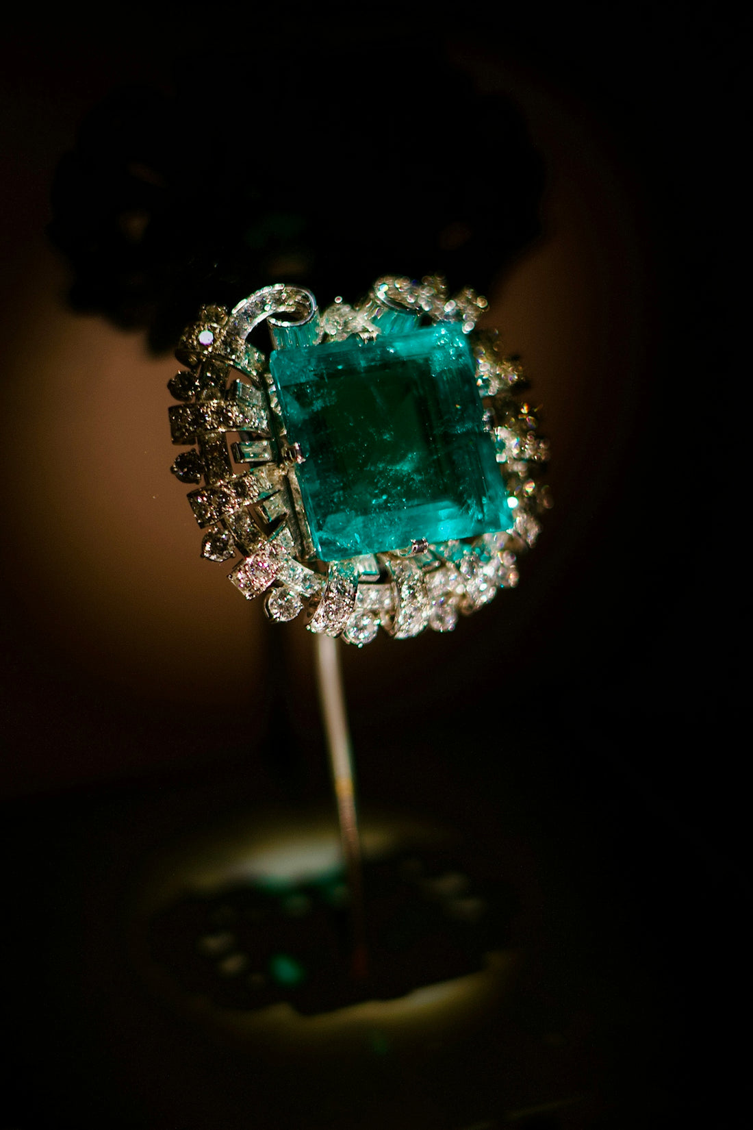 Emerald and diamond ring on display